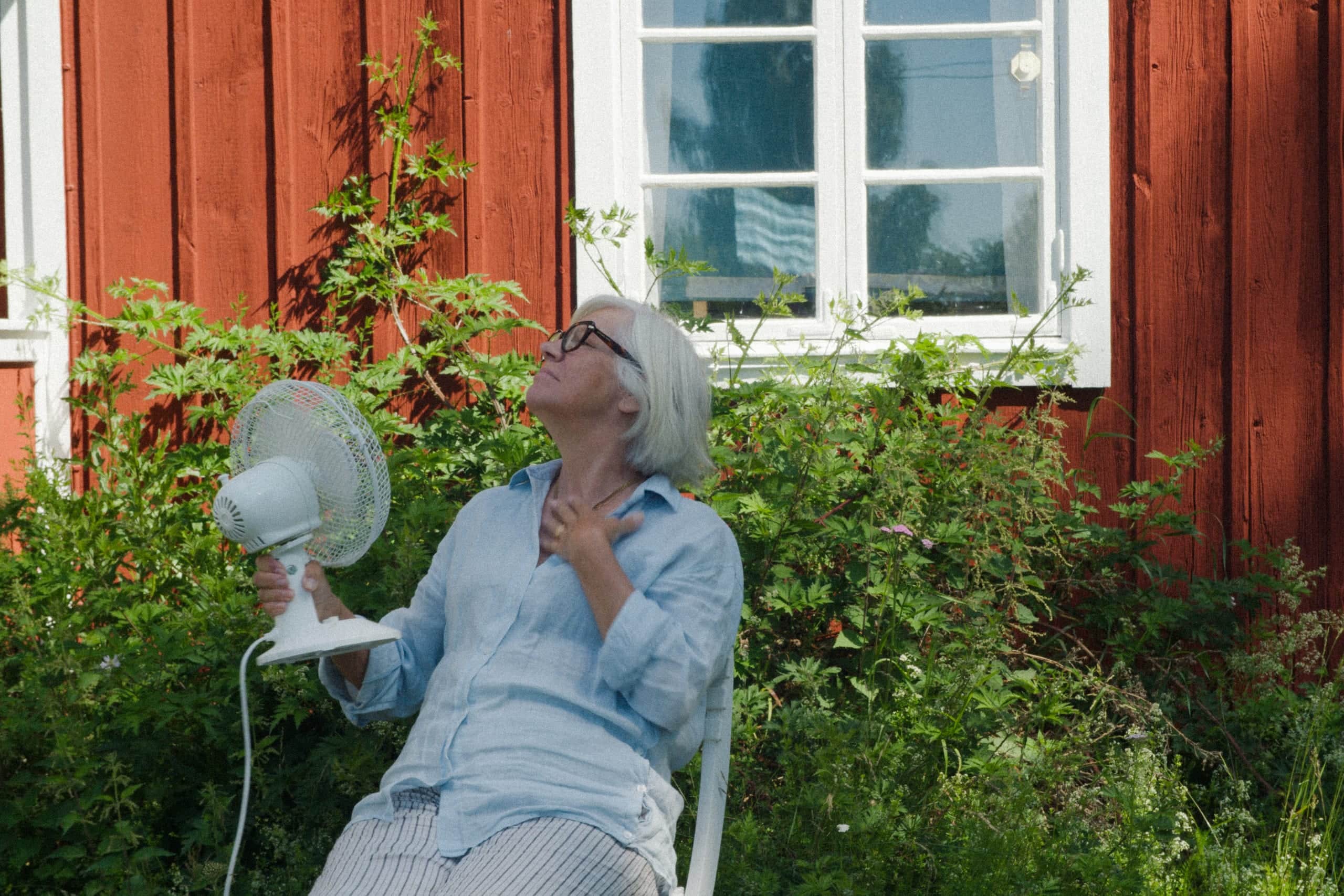 Elvy-kund vid trädgården till ett rött torp